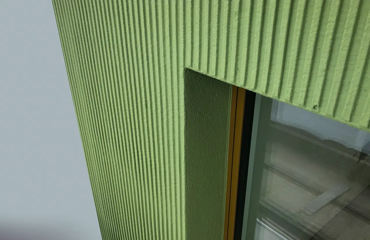 Octavo Oerlikon: grüne Putzfassade mit Fensteranschluss