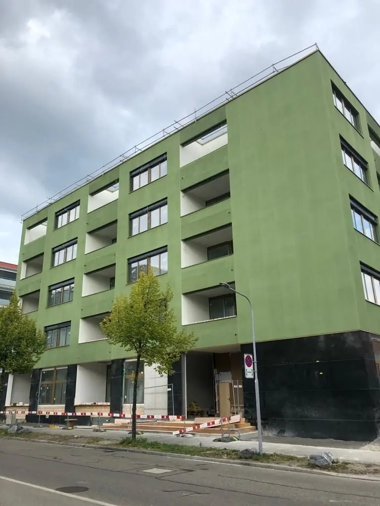 Octavo Oerlikon: grüne Putzfassade eines Wohnbaus